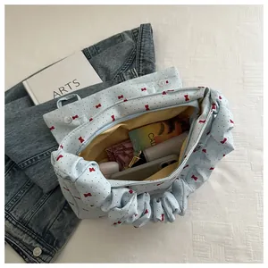 Detail of light blue bow-print tote bag showing spacious interior with zipper closure
