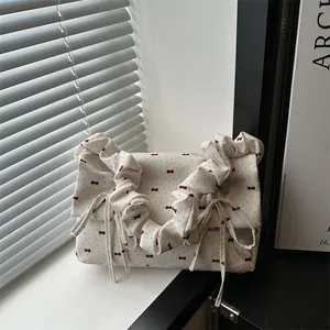 Chic cream tote bag with red bow prints and ruffled handles for a vintage look