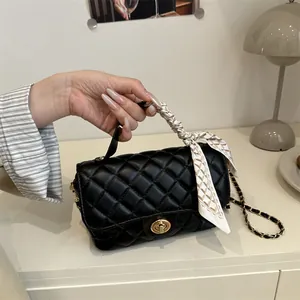 Classic black quilted leather handbag with gold twist lock and elegant silk scarf handle