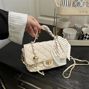 Beige quilted leather crossbody bag with gold chain strap and silk scarf handle detail