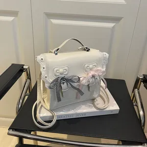 Chic white lace backpack with cute bow details on a vintage chair setup