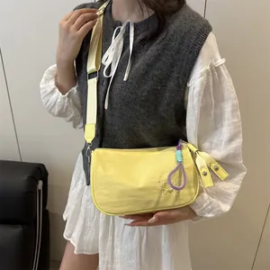 Bright yellow nylon pillow bag for women with wide strap and colorful rope charm