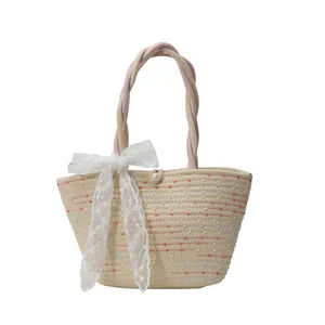 Handwoven straw tote bag with colorful floral embroidery and white lace bow detail