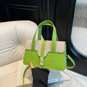 Chic green and beige contrast handbag with gold hardware and removable shoulder strap
