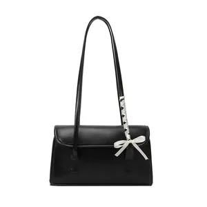 Elegante bolso baguette de cuero sintético negro con lazo de satén blanco en la correa