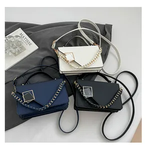 Modern rectangular shoulder bags in ivory, navy, and black with woven chain and metal buckles