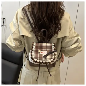 Mini backpack featuring brown checkered flap with ruffles and sweet bow detail