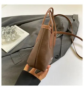 Close-up of brown litchi pattern bucket bag with small metal logo and side seam detail