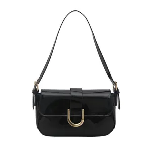 Glossy black patent leather shoulder bag with stylish gold horseshoe buckle design