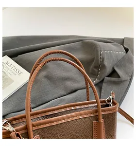 Detail of lychee textured leather bucket bag with silver hardware and dual handles