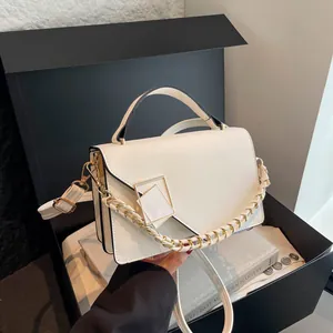 White minimalist crossbody handbag with geometric gold buckle in a luxury gift box
