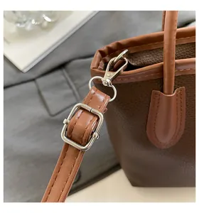 Close-up of dark brown lychee leather bucket bag with silver hardware and adjustable strap
