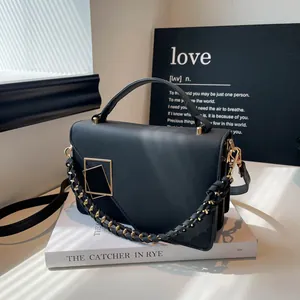 Elegant black faux leather crossbody bag with golden metal clasp and chain strap