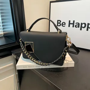 Chic black PU leather handbag with gold geometric buckle and woven chain for women
