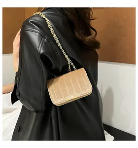 Detalle del bolso bandolera de terciopelo dorado con lentejuelas y cadena de metal dorado
