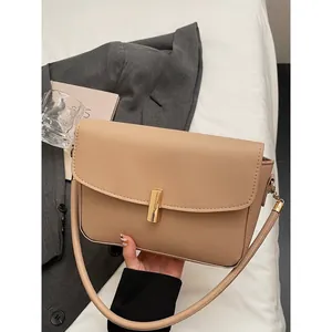Elegant apricot faux leather shoulder bag with gold metal buckle on a minimalist setting