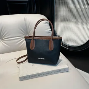 Chic black and brown leather bucket bag for women with fashion metal tag and shoulder strap