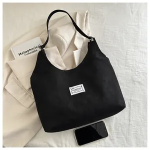 Dettaglio della borsa hobo in velluto nero con etichetta quadrata bianca fashion logo