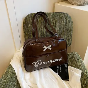 Dark brown patent leather shoulder bag with a white bow and Gonandnd embroidery
