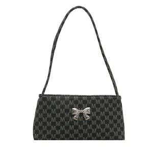 Fashionable black underarm bag with silver M-pattern print and metal butterfly detail
