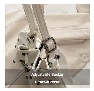 Dettaglio della fibbia in metallo regolabile e rivetti vintage su borsa a secchiello