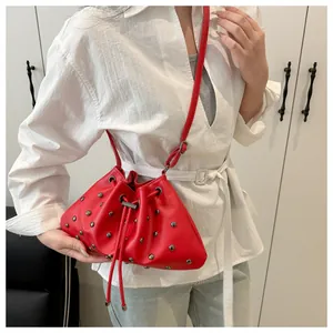 Dettaglio della borsa a secchiello rossa con coulisse e borchie in metallo argento