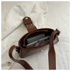 Vue de dessus de l'intérieur d'un sac à bandoulière marron foncé montrant la grande capacité