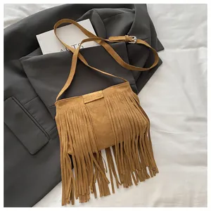 Detailaufnahme der braunen Wildledertasche mit langen Fransen und Verstellgurt