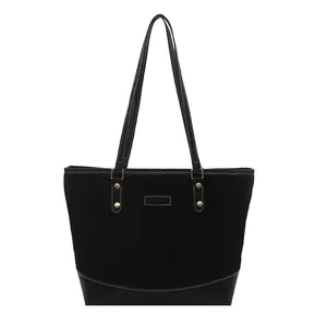 Large black patchwork tote bag with contrast stitching and golden metal hardware
