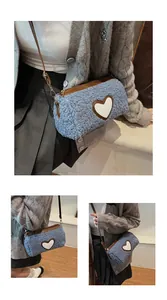 Détail du sac à bandoulière en peluche bleue avec patch cœur blanc et bordure cuir