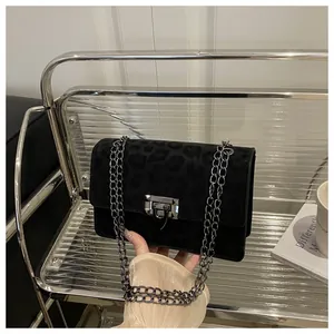 Detail der schwarzen Wildledertasche mit Leopardenmuster, Kette und Drehverschluss