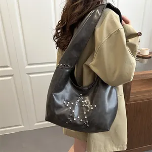Chic dark grey faux leather tote bag with silver star rivets shown on a model