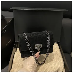 Detail der Leopardenmuster-Tasche mit Metallkette und Drehverschluss in einer Geschenkbox