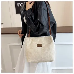 Détail du sac à épaule en fausse fourrure crème avec logo en cuir et bandoulière fine