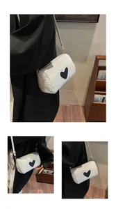 Détail d'un sac bandoulière en peluche blanche avec écusson cœur noir et fermeture éclair