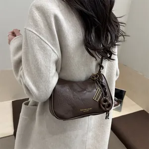 Borsa sottobraccio a mezzaluna marrone scuro in pelle vintage con ciondoli dorati