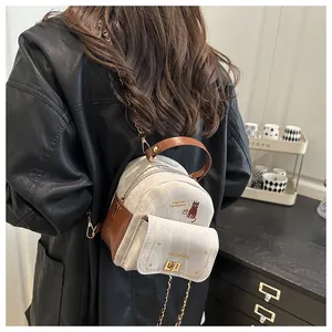 Vista posterior de una mujer con mini mochila de lona con dibujo de gato y cadena