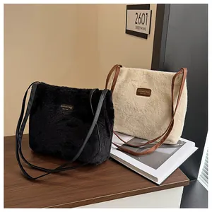 Detail of plush faux fur tote bags in black and beige with sleek leather shoulder straps