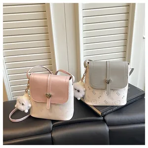 Detail van mini crossbody tassen met kattenpatroon, hartsluiting en pluchen hangers