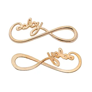 Close-up of golden infinity symbol connectors with lucky lettering for DIY jewelry making