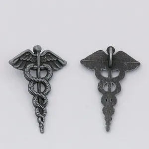 Detailed macro view showing the front and back of the vintage silver caduceus charm