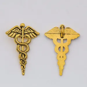 Pair of vintage gold alloy Caduceus pendants with detailed medical wing and snake texture