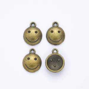 Set di quattro ciondoli vintage a forma di faccina in bronzo con asole per gioielli fai da te