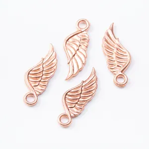 Macro dettagliata di ciondoli a forma di ala in lega di zinco oro rosa con piume intrecciate