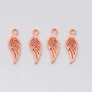 Close-up of four rose gold wing charms for DIY jewelry making with top hanging rings