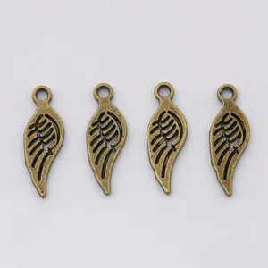 Detailed view of four vintage bronze alloy wing pendants with intricate feather textures