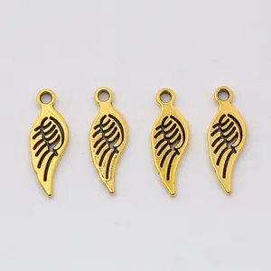 Close-up of four antique gold alloy wing charms with detailed feather texture for DIY jewelry