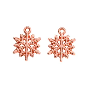 Makroaufnahme von zwei Schneeflocken-Anhängern in Roségold für DIY-Schmuck mit Ösen