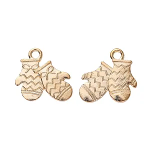 Macro detail of two golden vintage mitten charms with delicate bow textures and top loops