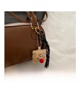 Détail du charm biscuit en peluche avec broderie étoile sur un sac bowling marron